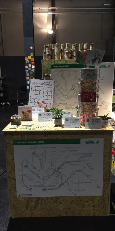 Selbstgebauter Messestand von MOLD mit Visitenkarten, Stickern, Sukkulenten, einer Holzscheibe, Maskingtape-Design, dem Lininenetz-Kalender, einem Postkarten-Ständer, Adventskalender-Bingo, Weihnachtskarte „Merry Foxmas“ und Preisschildern — Für kreatives Messestand-Design zum Entdecken