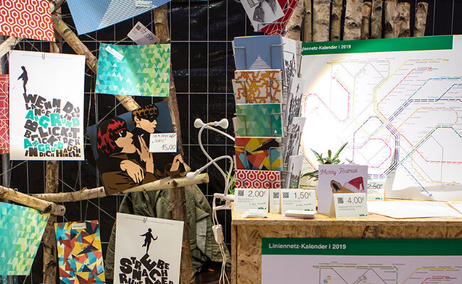 Messestand mit ausgefallenen Postern, Postkarten und individuellem Design — das Highlight für die Präsentation unserer Produkte