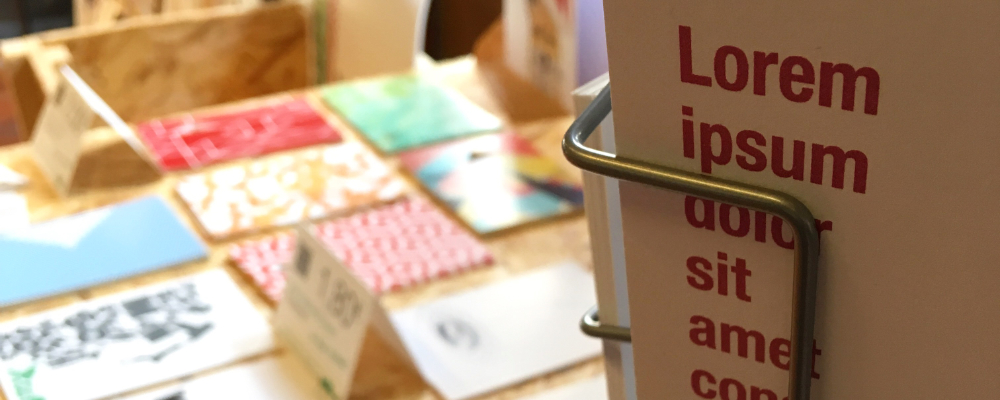 Postkartenständer und Messetisch mit einer großen Auswahl an MOLD-Postkarten – Präsentation am Messestand Light beim FAEX Pop-up in Esslingen.