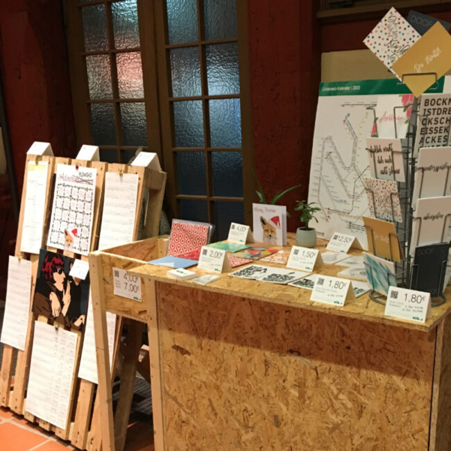 Messetisch mit Postkartenständer und vielen MOLD-Postkarten – Teil des Messestands Light beim FAEX Pop-up in Esslingen.