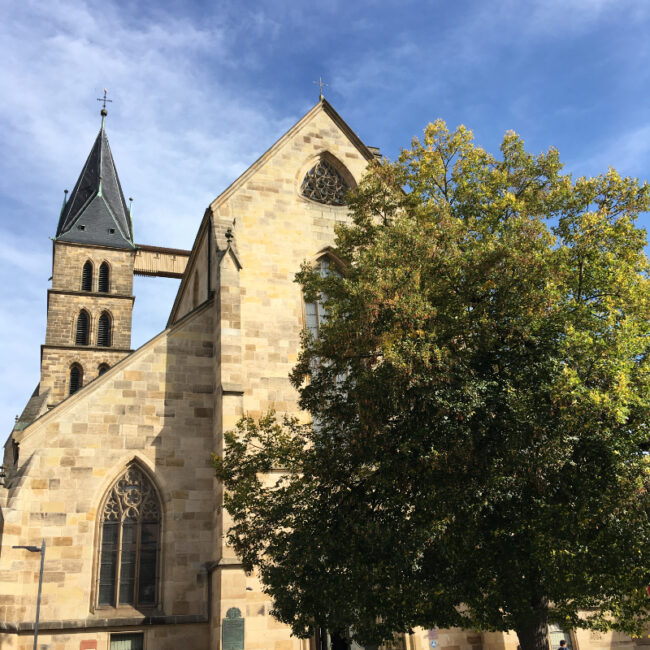 Stadtkirche St. Dionys in Esslingen vor blauem Himmel – Kulisse für unseren Messestand Light beim FAEX Pop-up.