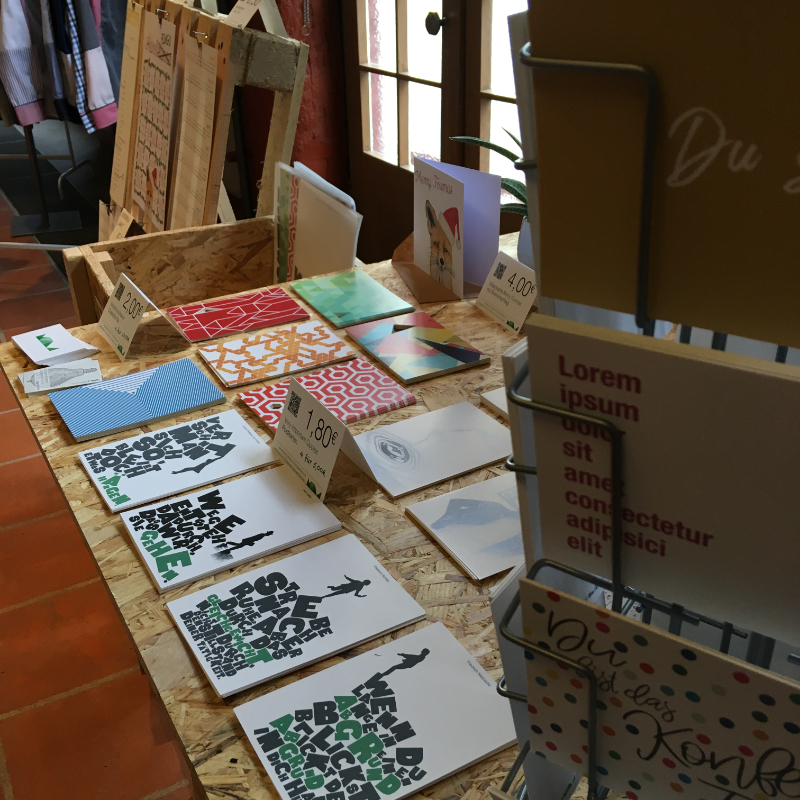 Postkartenständer und Messetisch mit einer großen Auswahl an MOLD-Postkarten – Präsentation am Messestand Light beim FAEX Pop-up in Esslingen.