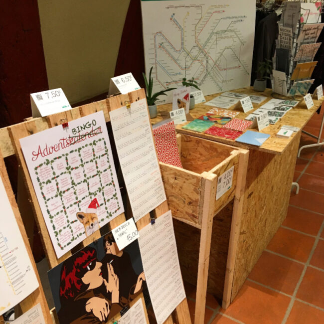 Messetisch mit Postkartenständer und vielen MOLD-Postkarten – Teil des Messestands Light beim FAEX Pop-up in Esslingen.