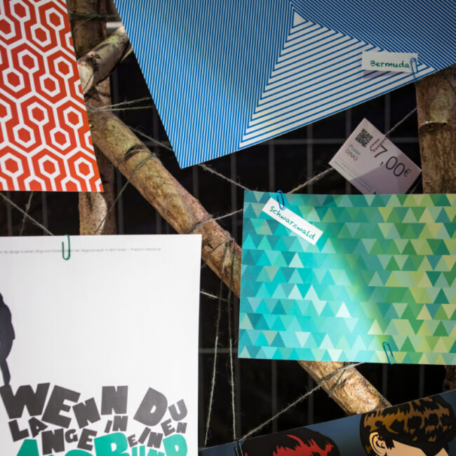 Messestand von MOLD: Poster an der mit Garn umwickelten Birkenstamm-Wand